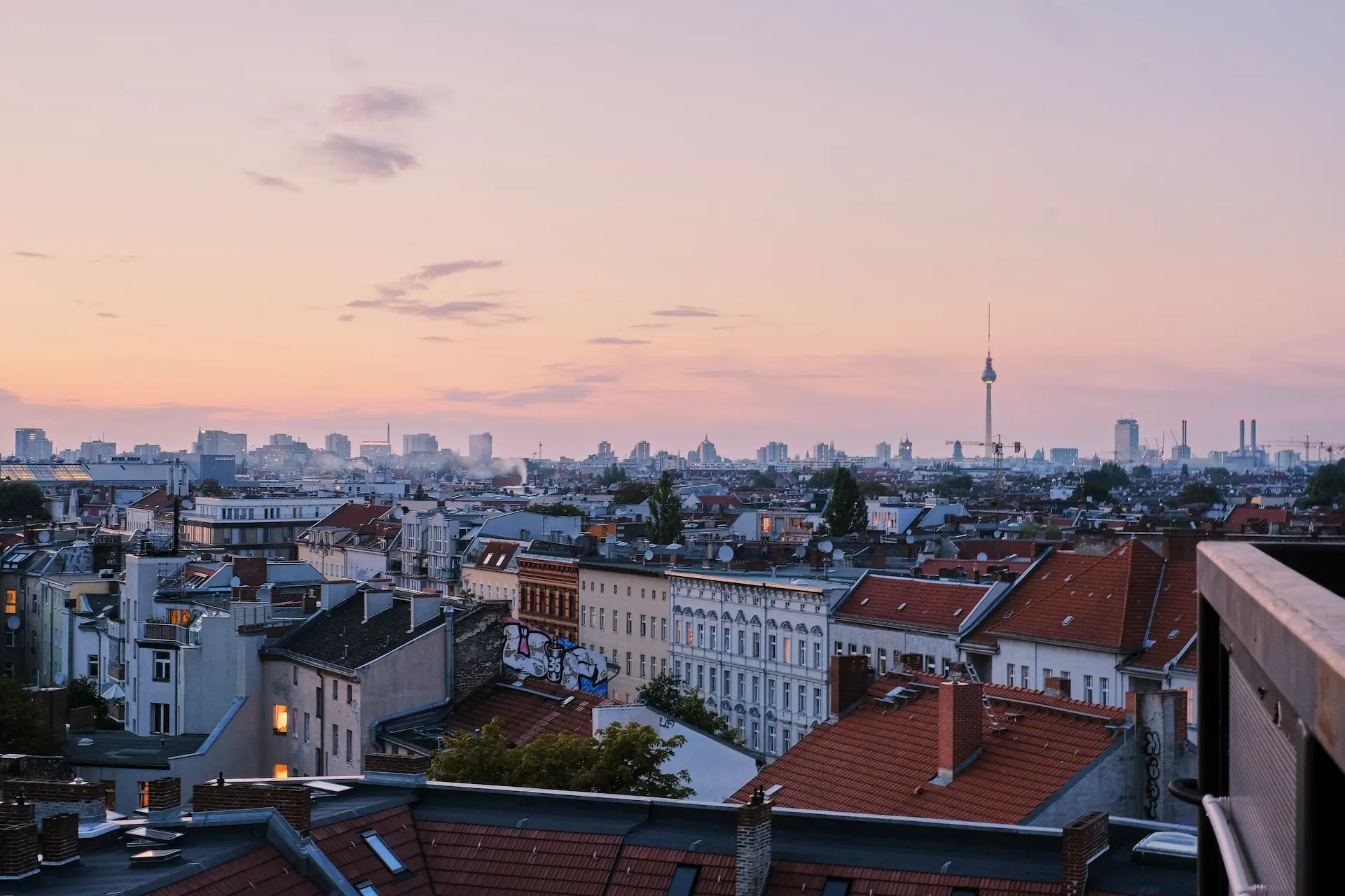 City skyline at sunset with TV tower on the horizon.