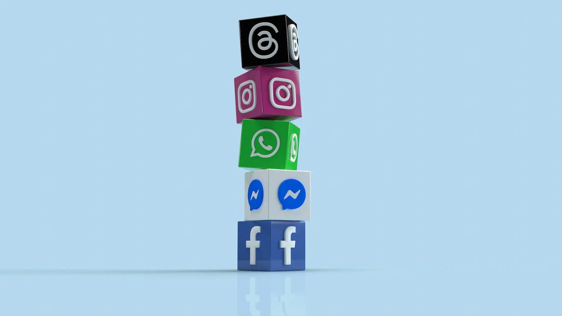Gestapelte Würfel mit Social-Media-Logos vor blauem Hintergrund.