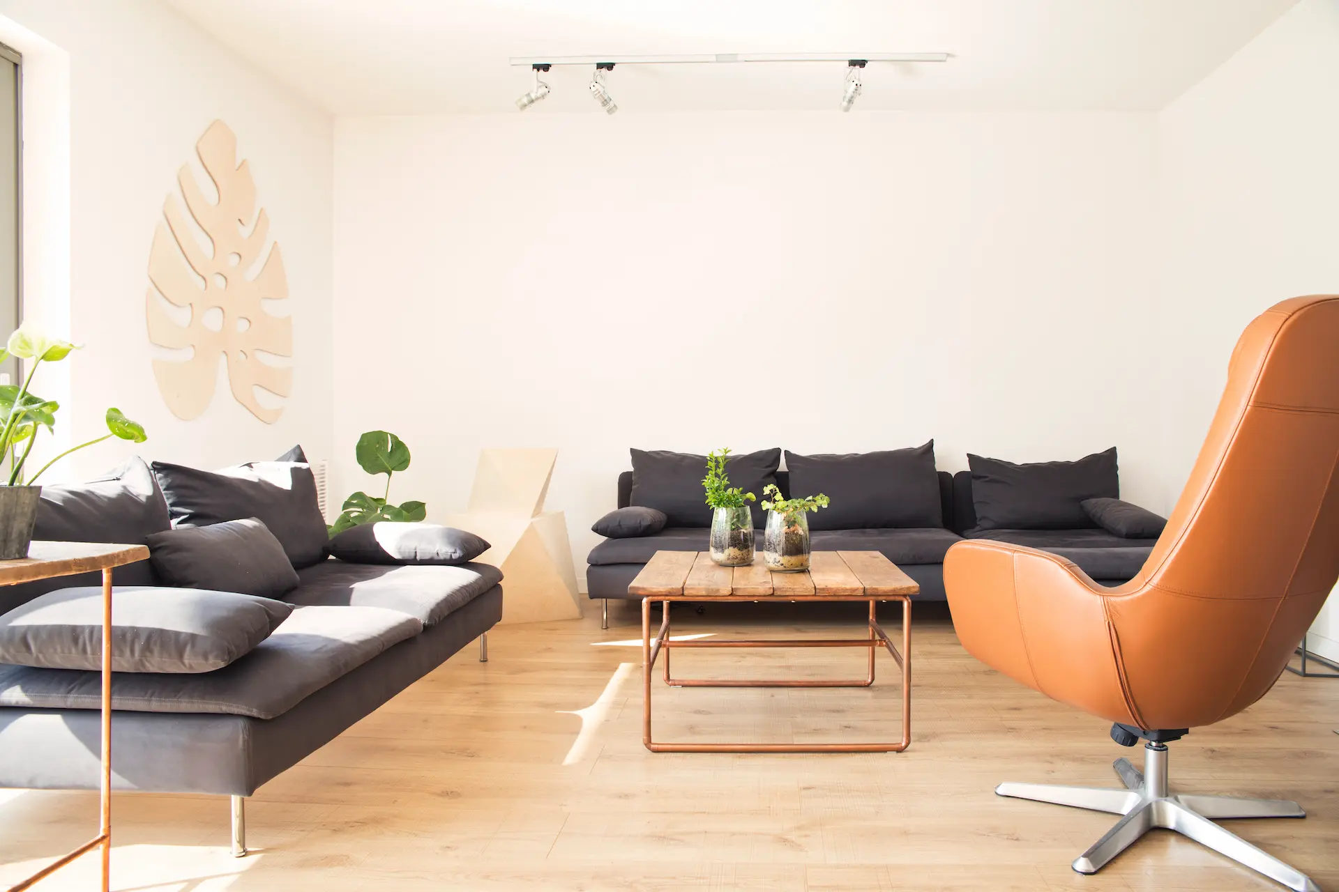 Modern living room with gray sofas, coffee table, and orange armchair.